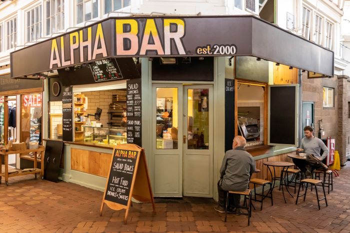 Alpha Bar in Oxford Covered Market with two men eating outside.