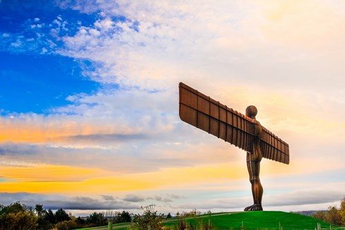The Angel of the North against a yellow and blue sky