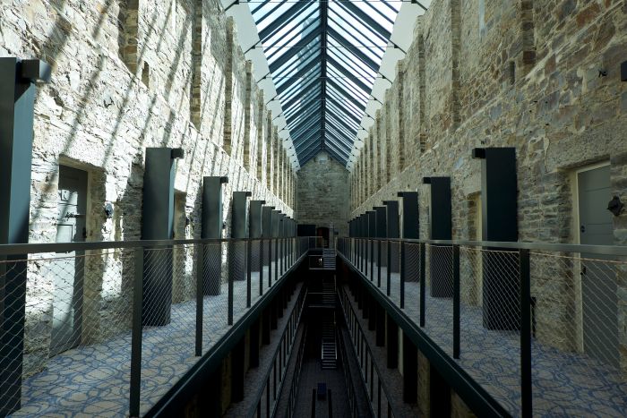 Interior of Bodmin Jail Hotel featuring stone walls, a glass roof, and modern walkways.