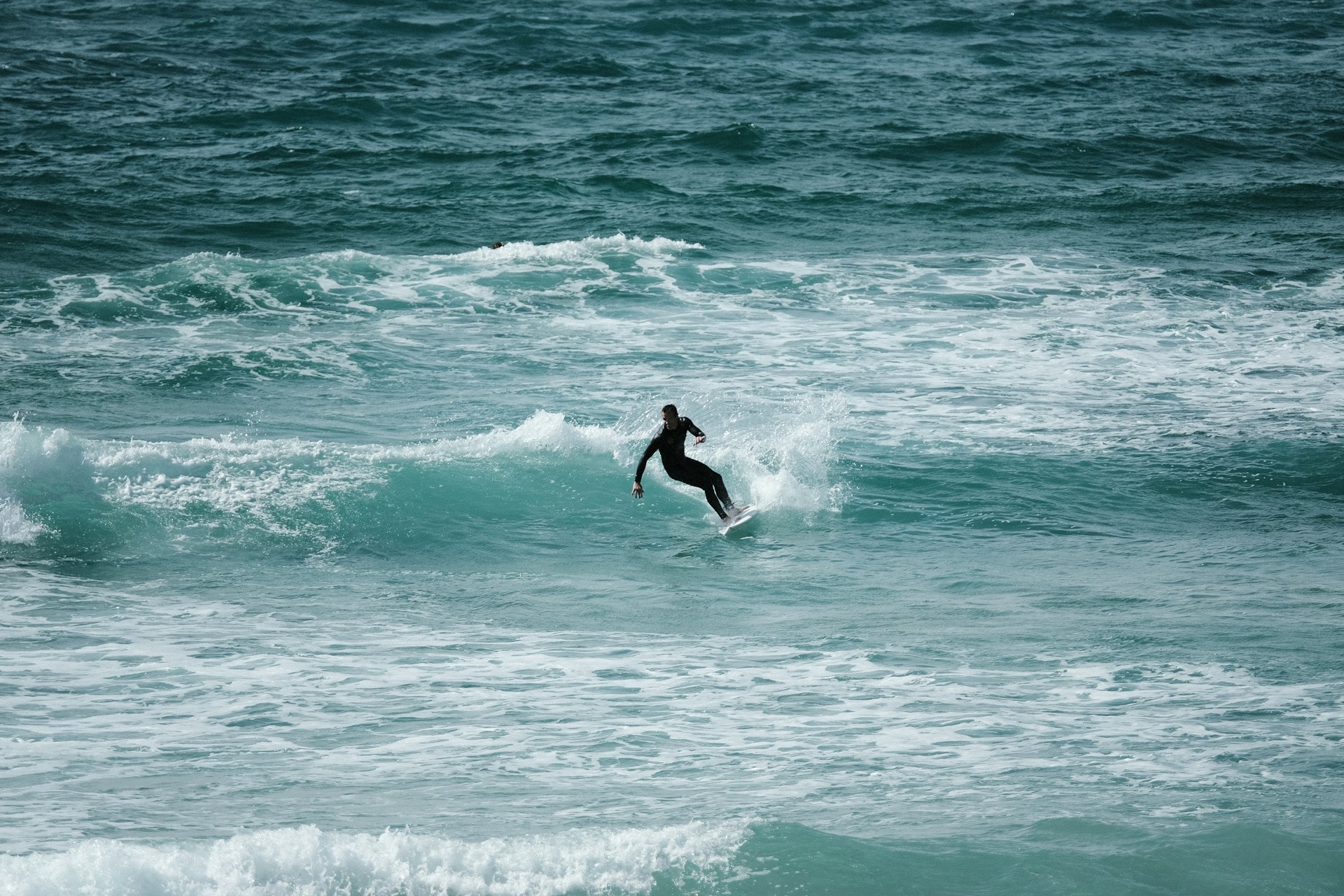 A surfer on Fistral beach in Newquay