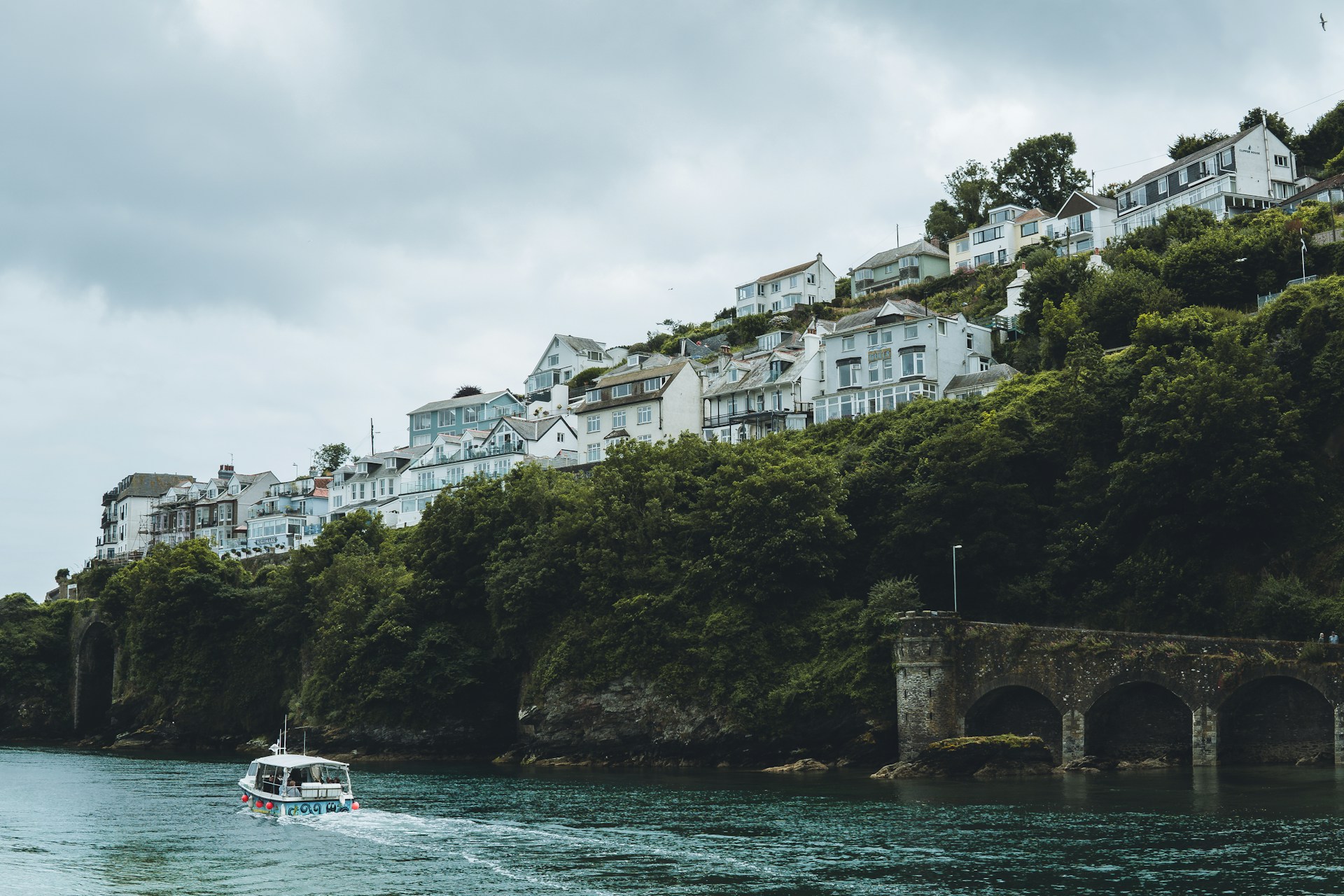 Houses on a cliff edge looking over Looe Bay