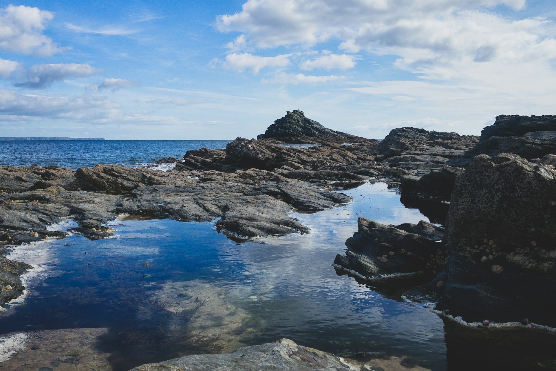 A shallow rockpool overlooking the sea in Looe