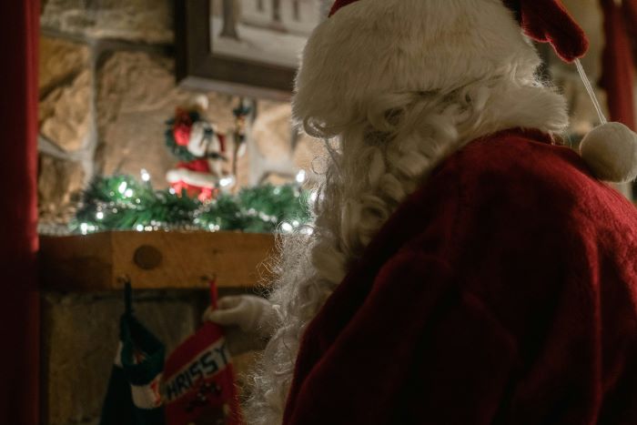 Father Christmas hanging a stocking up