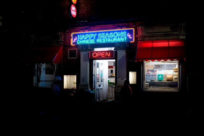 Neon sign of Happy Seasons restaurant at night time.