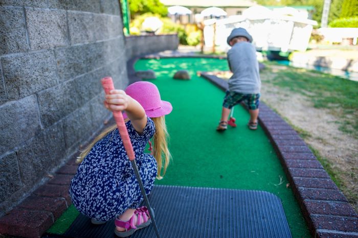 two small children playing crazy golf