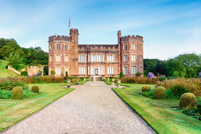 Mount Edgcumbe house viewed from the front, with a grand pathway lined with grass leading the way to enter the grand home.