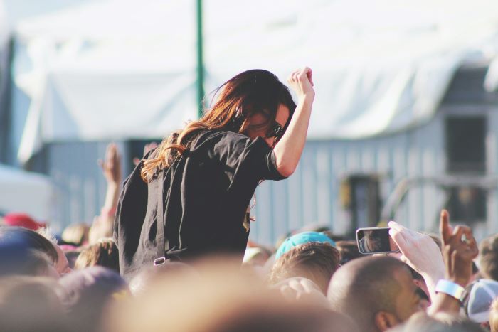 Woman on someone's shoulders at a festival