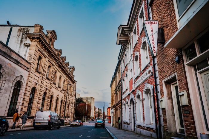 A street in Southampton with historic building lining the road and blue sky above.