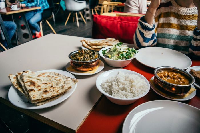 A person eating a vegan curry at a restaurant